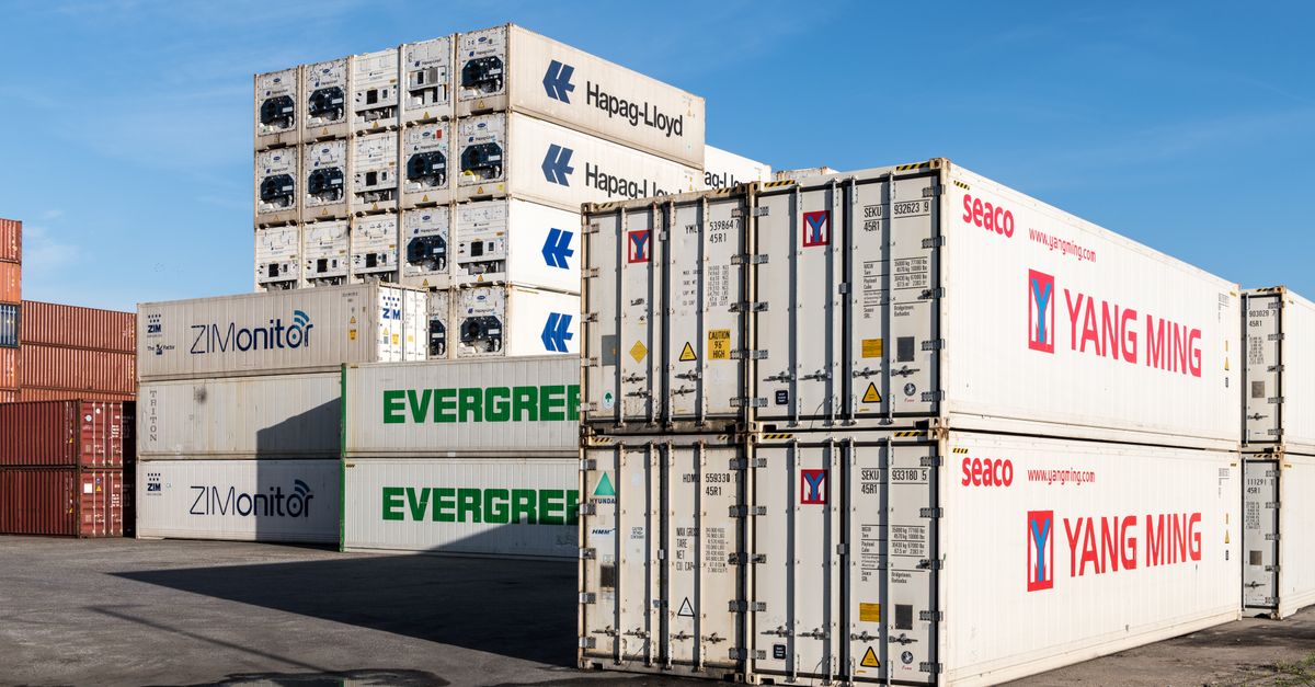 Contenedores apilados en una terminal portuaria al atardecer