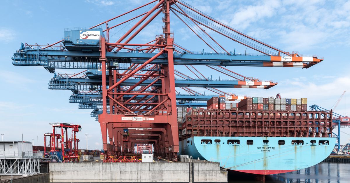Grúa portuaria cargando un contenedor sobre un buque de carga